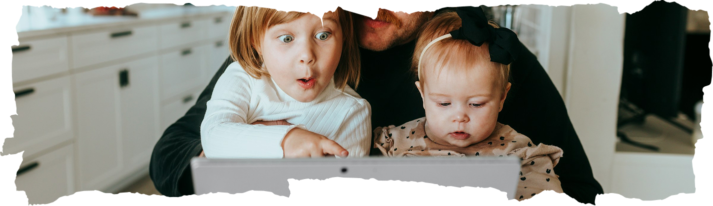 Otec s dvoma deťmi pozerá do notebooku – daňový bonus na dieťa